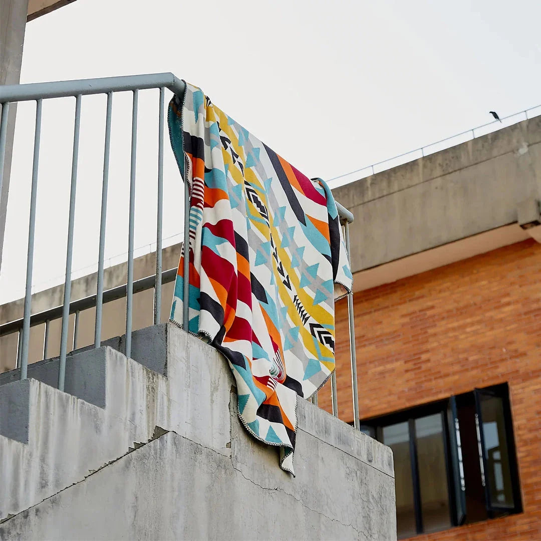 Cosy bohemian-style cotton blanket with vibrant geometric pattern, suitable for indoor and outdoor use