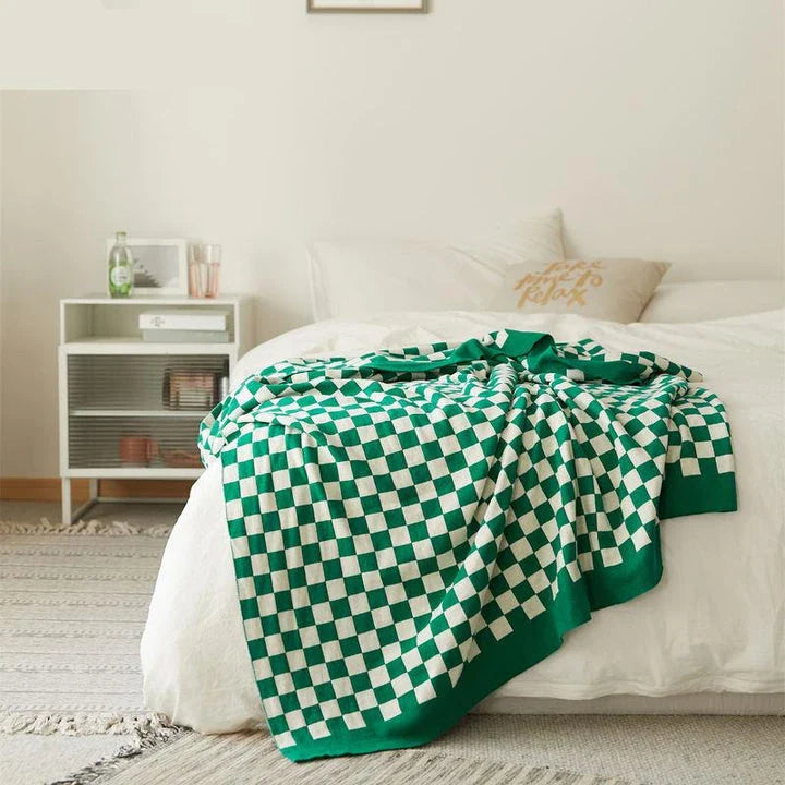 Cosy checkerboard plaid cotton knitted blanket in earthy tones of green, khaki, and black for stylish home decor