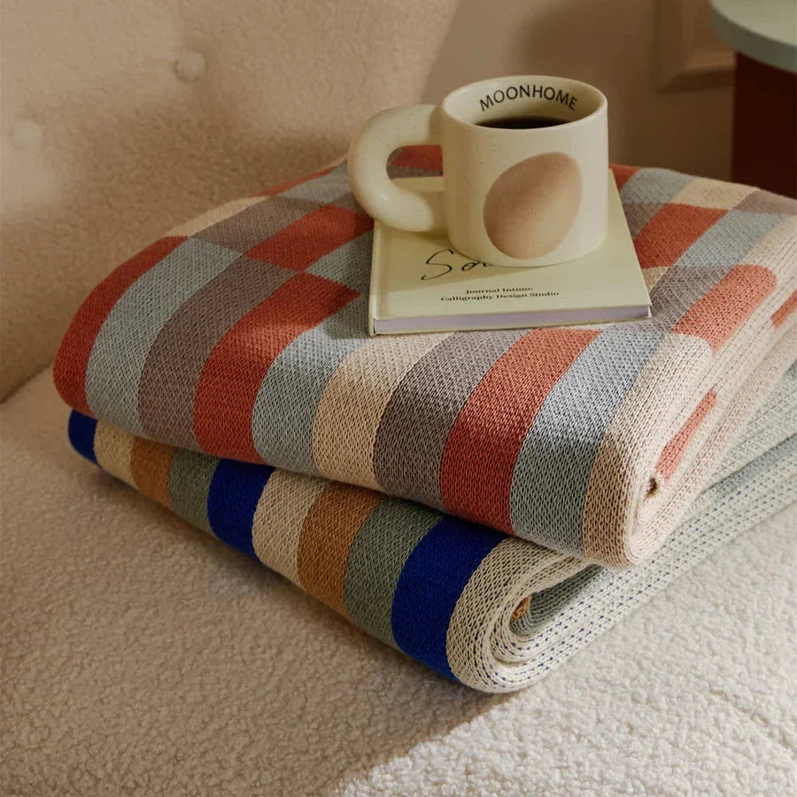Cosy 100% cotton striped plaid throw blanket in vibrant orange and blue hues, perfect for adding rustic charm to any living space.