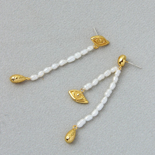 Pair of elegant, asymmetrical pearl earrings with a luxurious and sophisticated design
