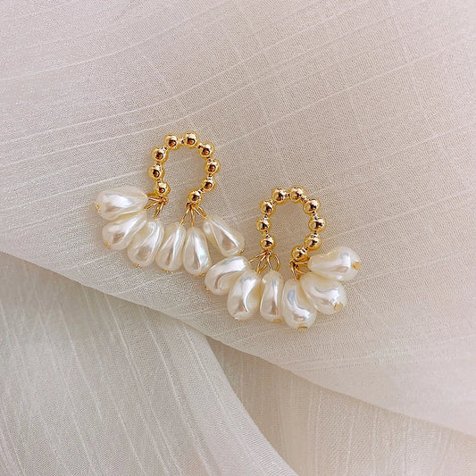 Pair of elegant Baroque-inspired pearl earrings with a silver and gold plated alloy setting