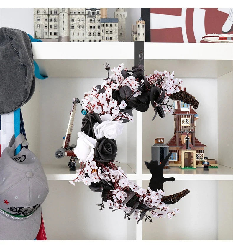Spooktacular Halloween garland featuring a blend of dried white flowers, black roses, and mystical moon cat ornaments