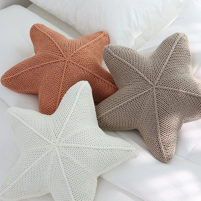 Artfully hand-knitted starfish-shaped cushion in a range of sophisticated colour options, providing plush comfort and coastal charm for any living space.