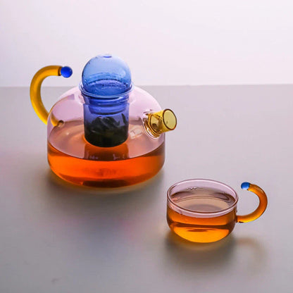 Elegant glass teapot and teacup set in vibrant contrasting colours, designed for a refined tea experience