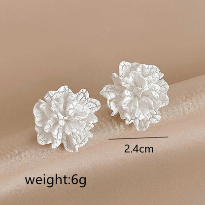 Elegant white floral stud earrings with a unique and captivating design, perfect for fashion-forward women in the UK
