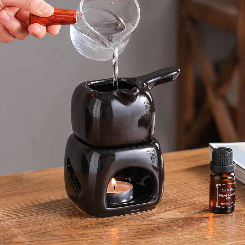 Elegant ceramic candle holder and tea warmer set in black, perfect for creating a cosy and relaxing atmosphere in your home.