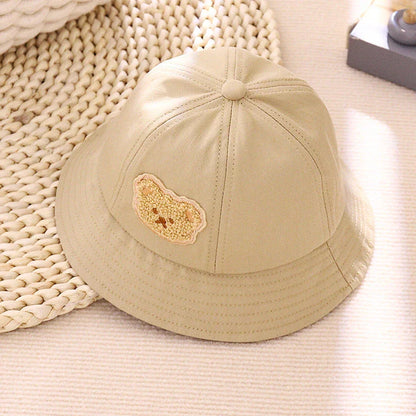 Cartoon Baby Hat in White Colour, Featuring a Playful Cartoon Pattern and Fitted Strap for a Comfortable Fit