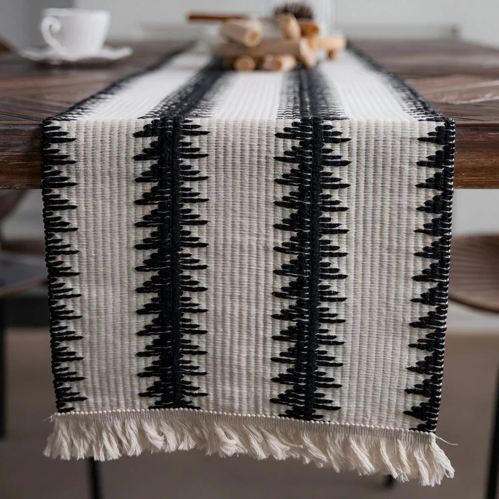 Elegant black and white cotton table runner with classic striped pattern and tassels, perfect for sophisticated dining decor