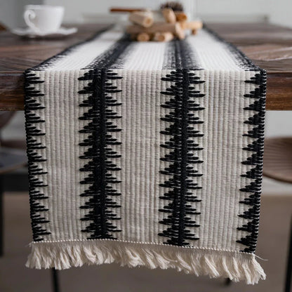 Elegant black and white cotton table runner with classic striped pattern and tassels, perfect for sophisticated dining decor