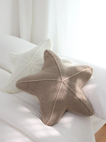 Artfully hand-knitted starfish-shaped cushion in a range of sophisticated colour options, providing plush comfort and coastal charm for any living space.