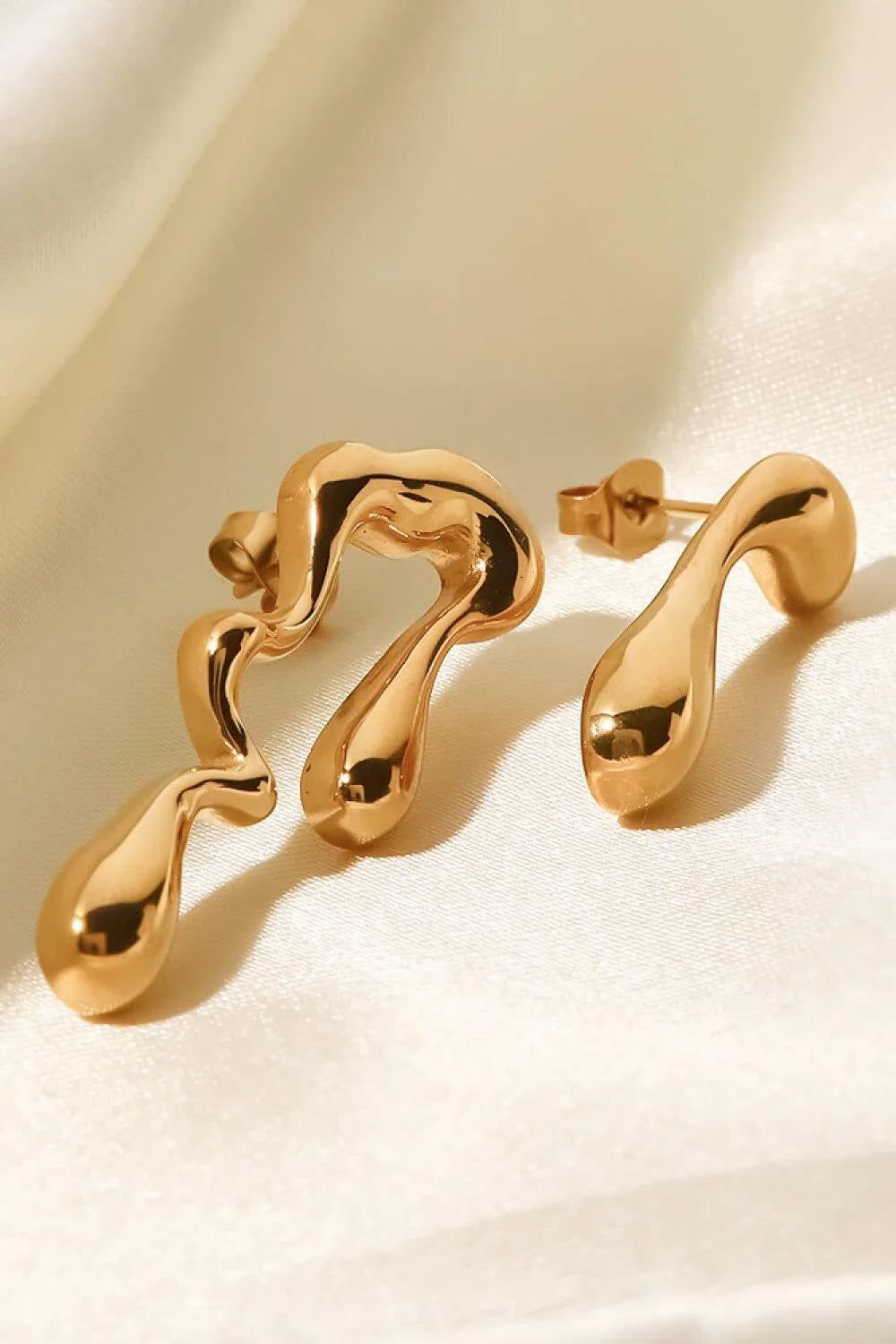 Pair of 18K gold-plated geometric mismatched earrings with varying lengths and shapes