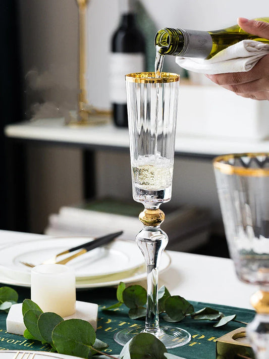 Elegant crystal wine glasses with refined gold vertical patterns, perfect for enjoying fine wines and champagne