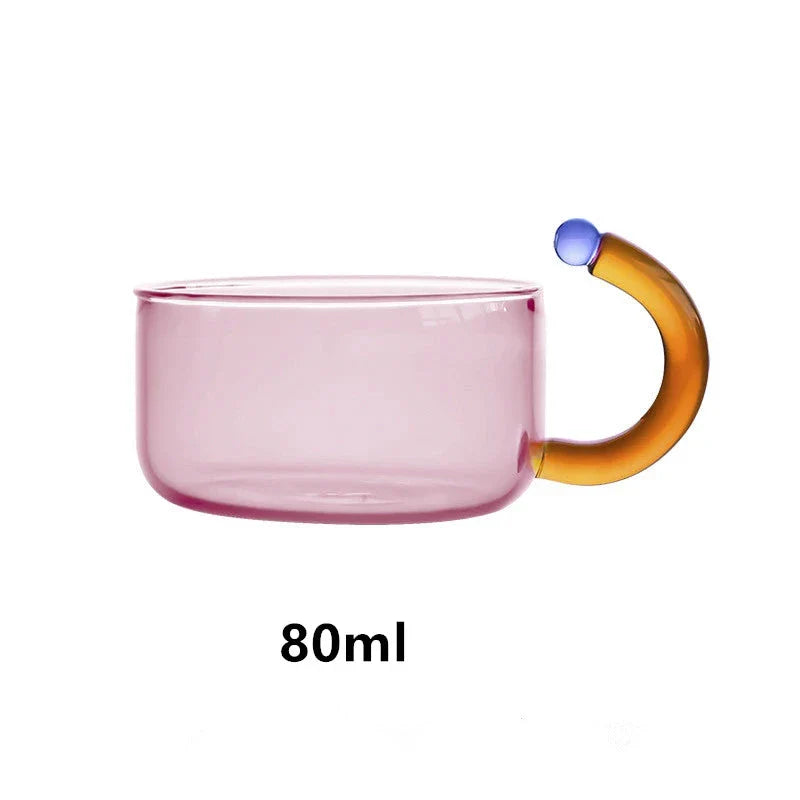 Elegant glass teapot and teacup set in vibrant contrasting colours, designed for a refined tea experience