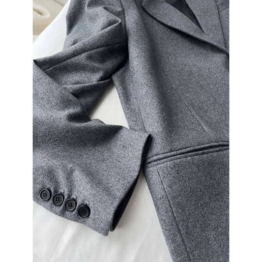 Elegant and refined women's woollen blazer with a wide-waisted silhouette, single-breasted closure, and turn-down collar