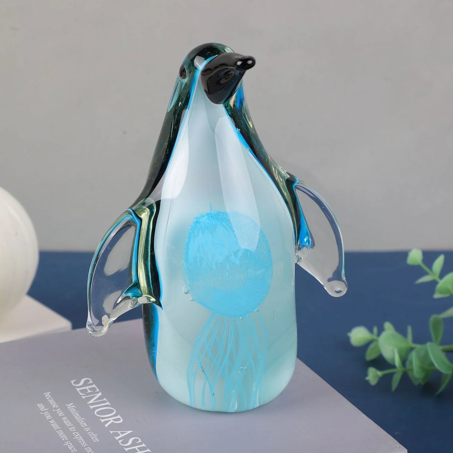 Exquisite handcrafted glass penguin ornament with a striking green-backed design, showcasing the beauty of marine life