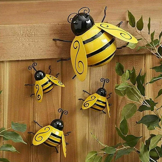 Four decorative metal bumble bee sculptures in a natural garden setting