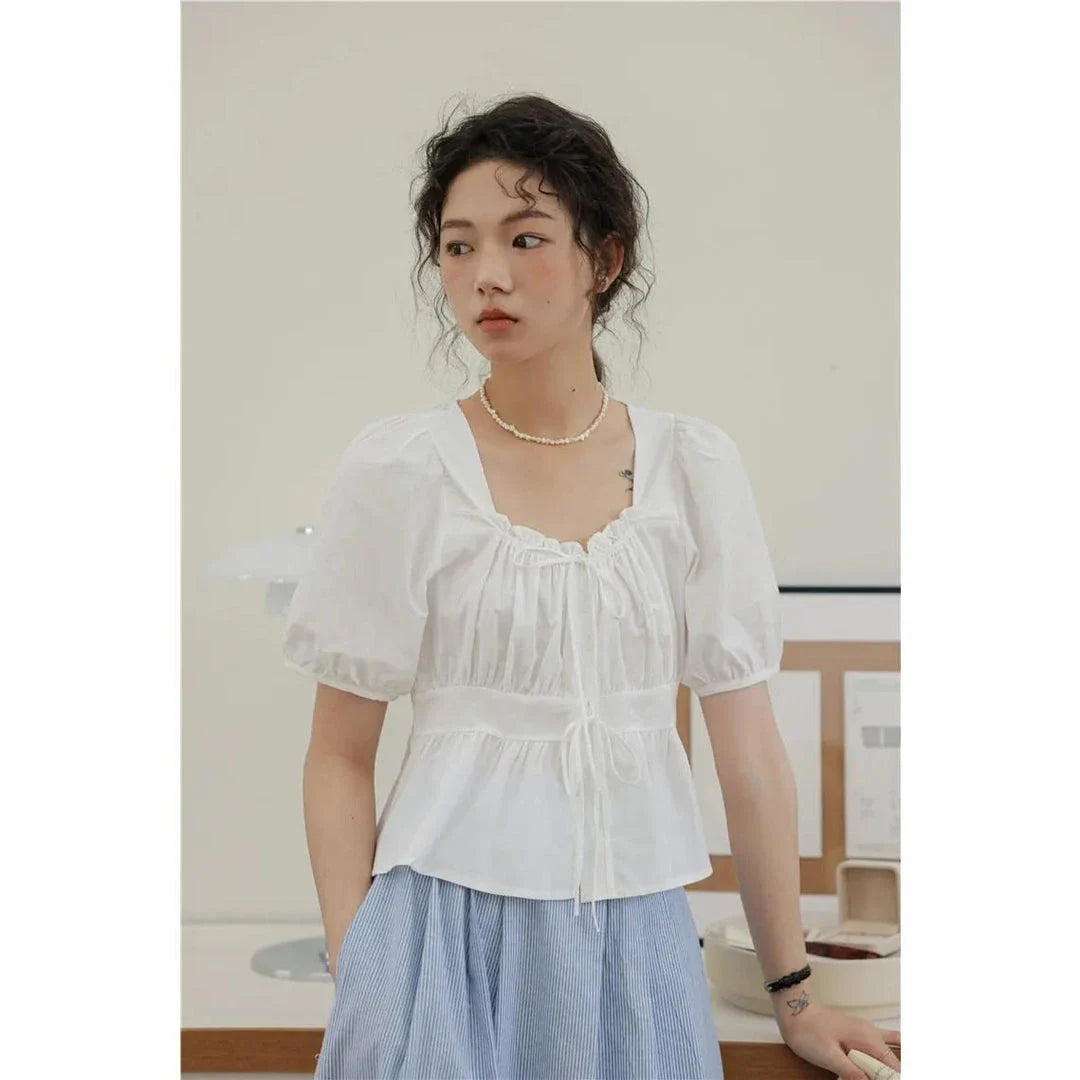 Elegant vintage white blouse with square neckline, puff sleeves, and lace-up detail