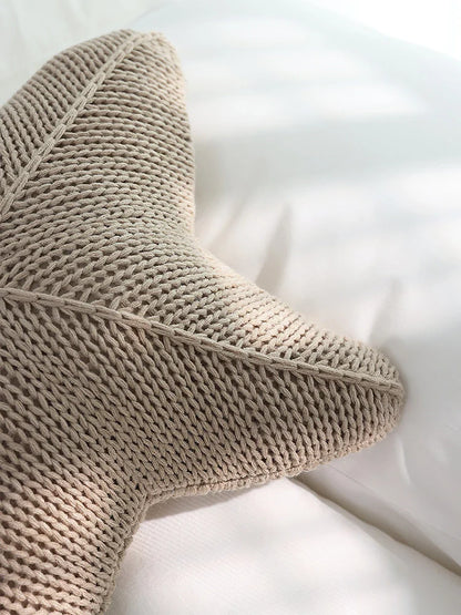 Artfully hand-knitted starfish-shaped cushion in a range of sophisticated colour options, providing plush comfort and coastal charm for any living space.