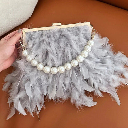 Elegant feather clutch bag with pearls and metal chains, a versatile and sophisticated evening accessory