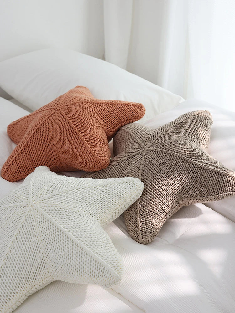Artfully hand-knitted starfish-shaped cushion in a range of sophisticated colour options, providing plush comfort and coastal charm for any living space.