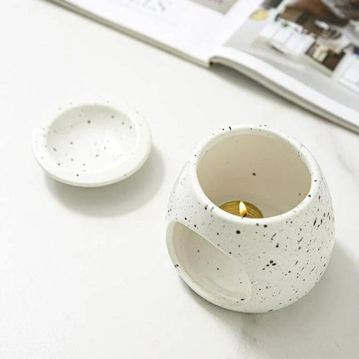 Elegant ceramic aroma diffuser with a unique spotted glaze design, perfect for creating a calming atmosphere in any room.