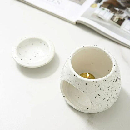 Elegant ceramic aroma diffuser with a unique spotted glaze design, perfect for creating a calming atmosphere in any room.
