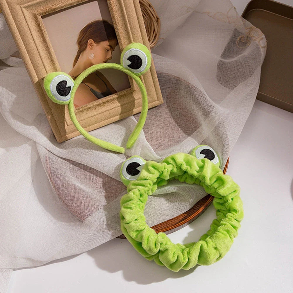 Charming frog-themed headband with plush coral fleece material and elastic band for a comfortable, customized fit