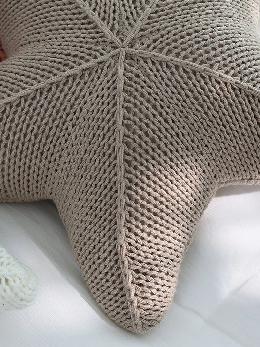 Artfully hand-knitted starfish-shaped cushion in a range of sophisticated colour options, providing plush comfort and coastal charm for any living space.