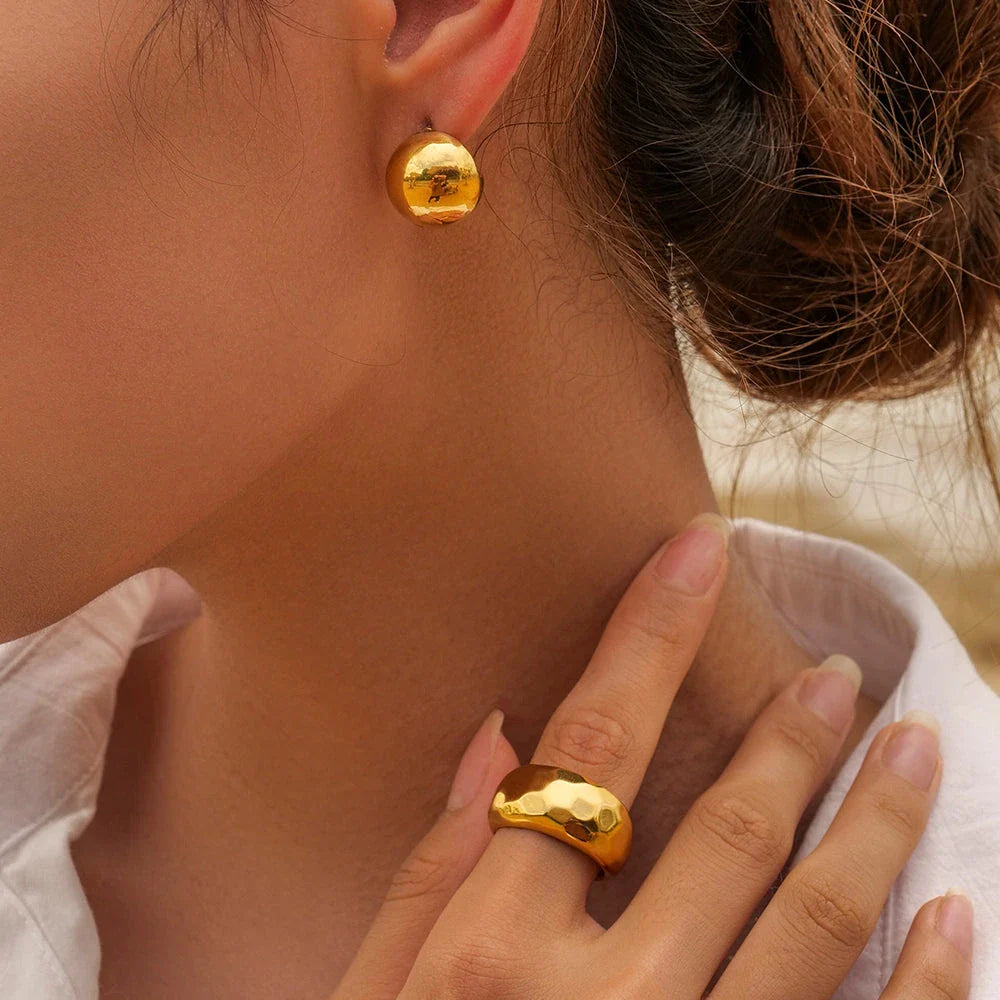 A pair of stylish, 18K gold-plated hemispherical cutout earrings with a sleek, sophisticated design