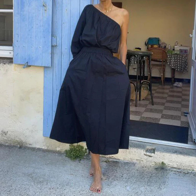 Elegant two-piece set with oblique shoulder blouse and midi skirt in black colour