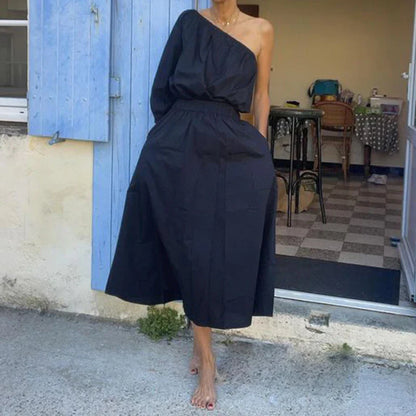Elegant two-piece set with oblique shoulder blouse and midi skirt in black colour