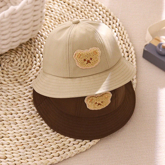 Cartoon Baby Hat in White Colour, Featuring a Playful Cartoon Pattern and Fitted Strap for a Comfortable Fit