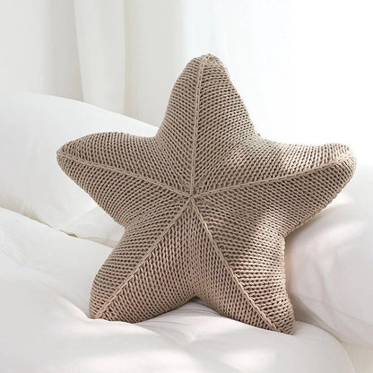 Artfully hand-knitted starfish-shaped cushion in a range of sophisticated colour options, providing plush comfort and coastal charm for any living space.