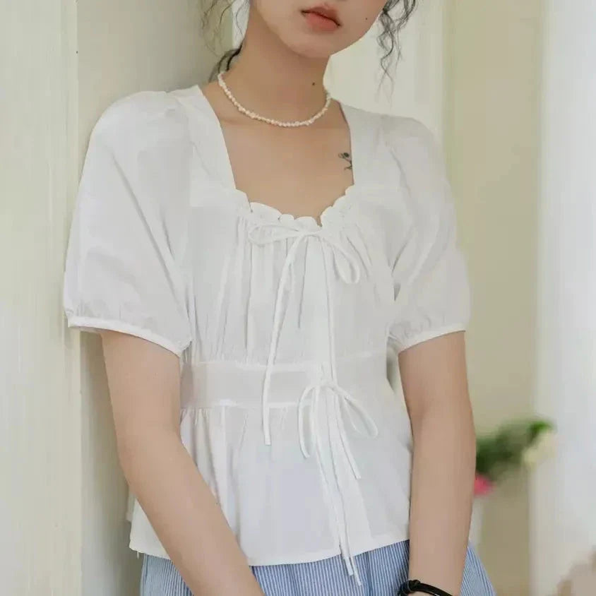 Elegant vintage white blouse with square neckline, puff sleeves, and lace-up detail