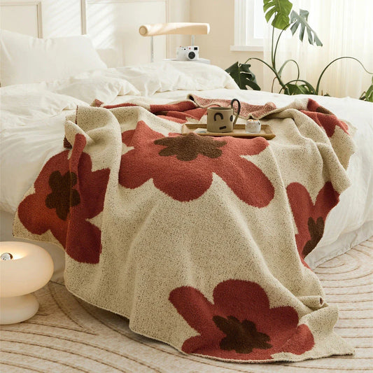 Cosy floral knitted throw blanket in red, grey, and orange shades - a high-quality microfibre accessory for year-round comfort and style