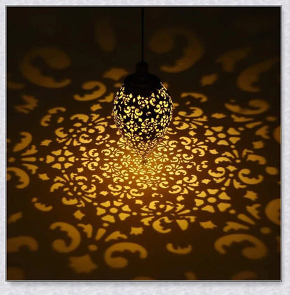 Decorative outdoor solar lanterns hanging in a lush garden, providing warm, ambient lighting