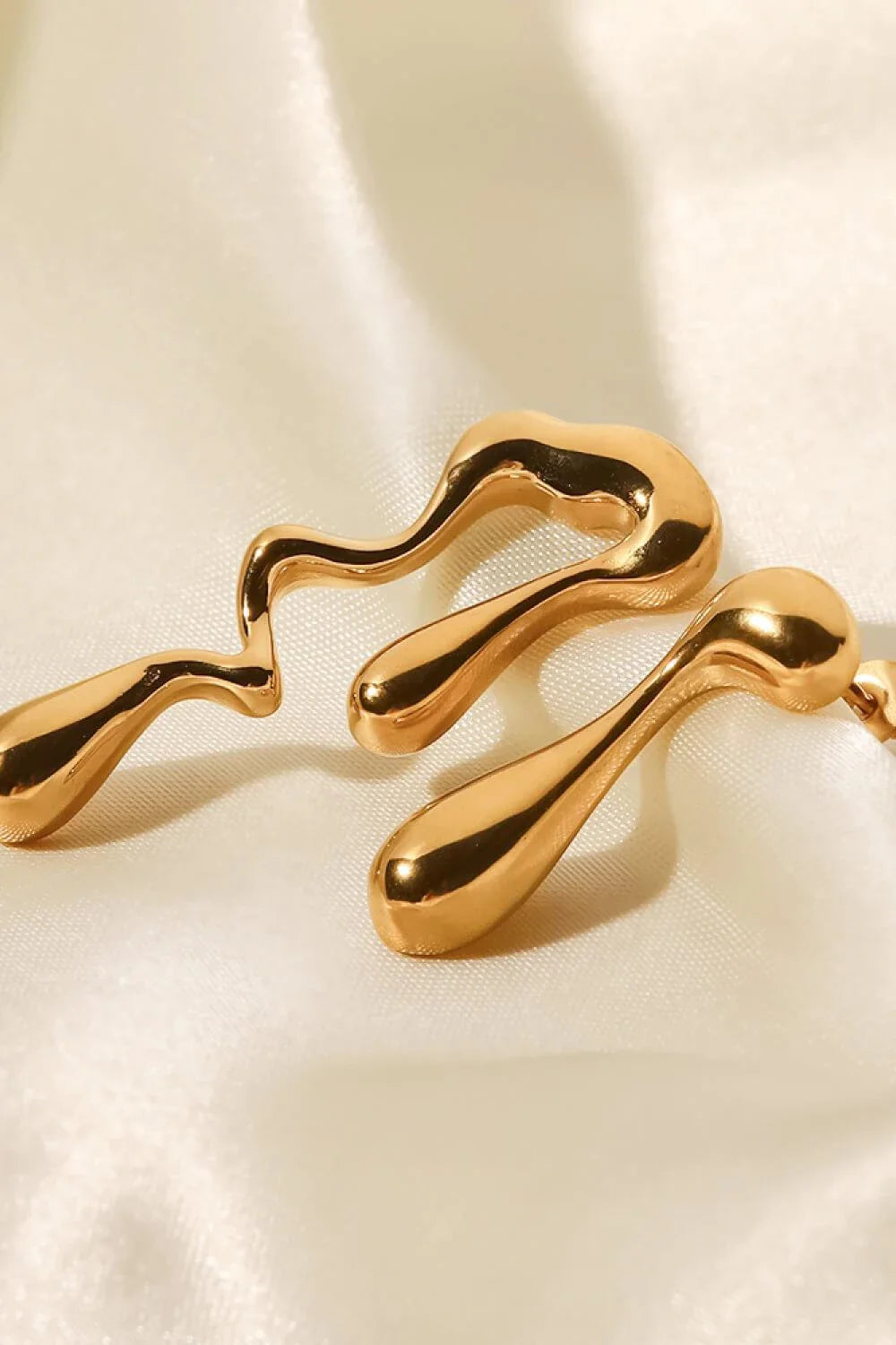 Pair of 18K gold-plated geometric mismatched earrings with varying lengths and shapes