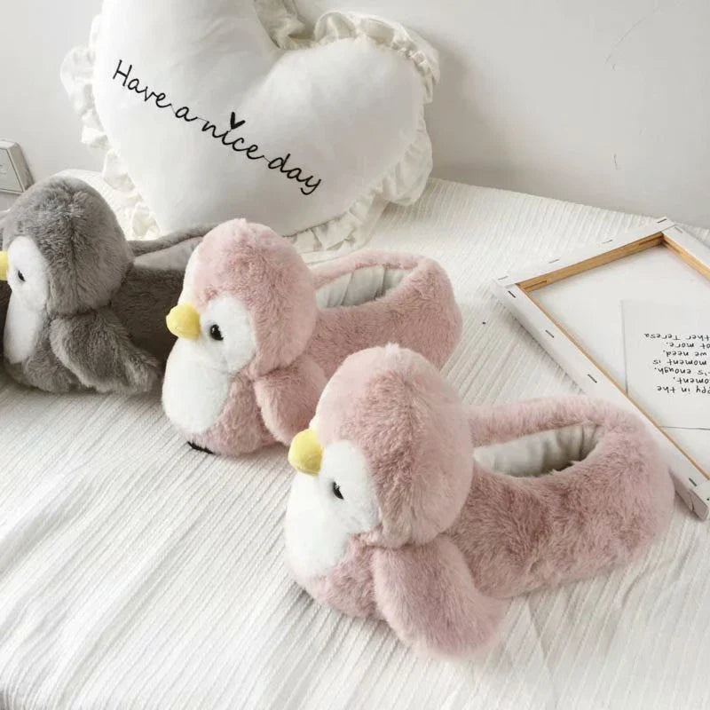 Pair of cosy, plush home slippers featuring a playful penguin design