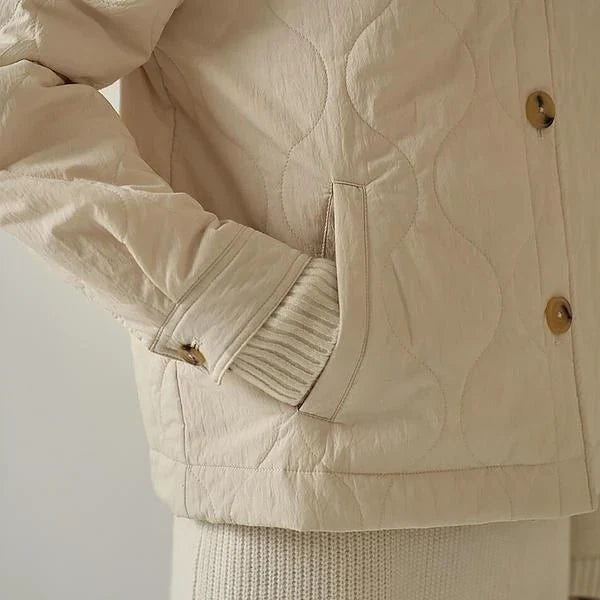 Women's quilted jacket in black, featuring a cosy v-neck collar, button detailing, and a regular fit for versatile winter style.