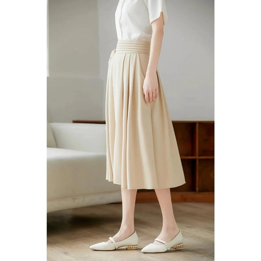 Elegant high-waisted pleated skirt with pockets in apricot colour, made from a blend of acrylic, cotton, and polyester for comfort and durability.