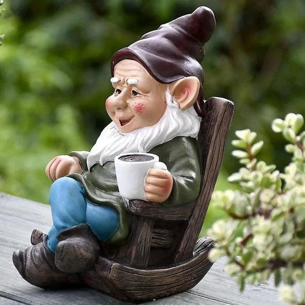 A charming garden gnome ornament made of durable resin, relaxing in a rocking chair and sipping tea, adding a whimsical touch to any outdoor space.