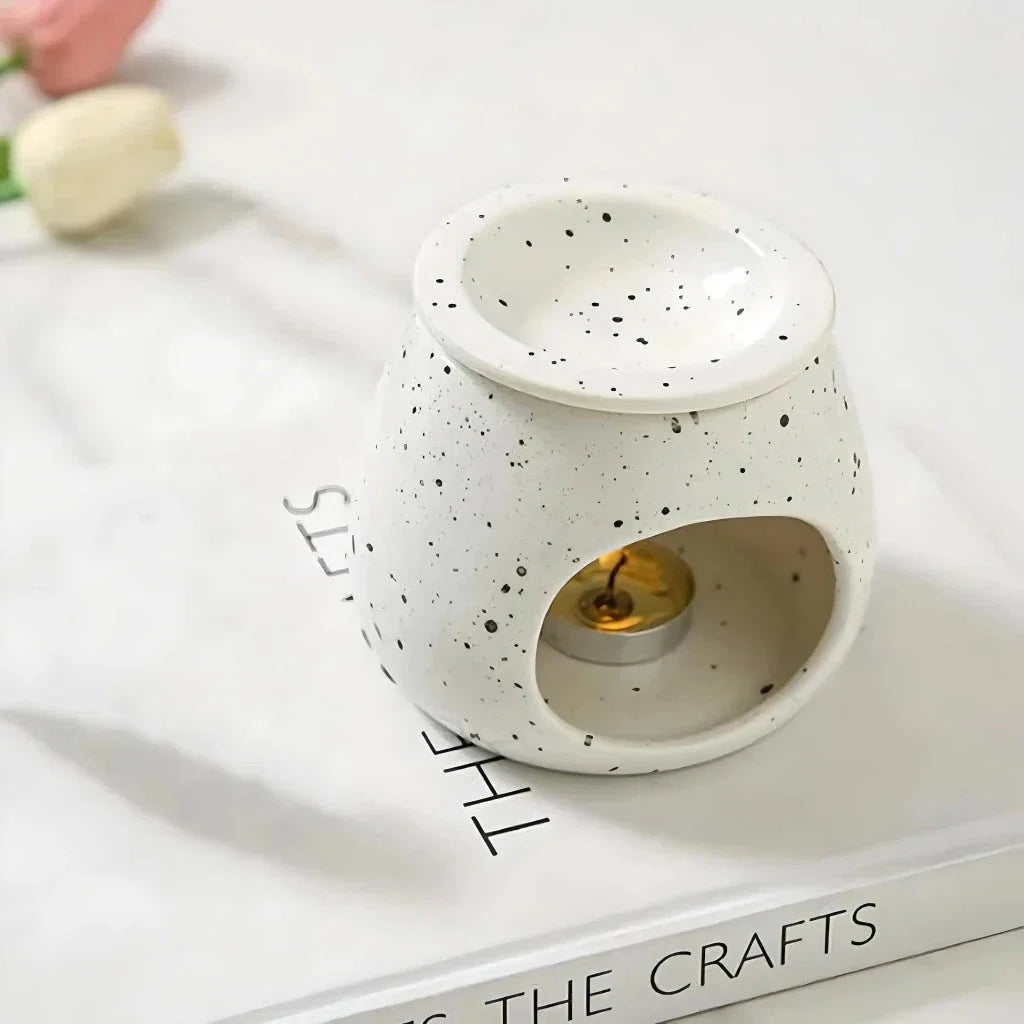 Elegant ceramic aroma diffuser with a unique spotted glaze design, perfect for creating a calming atmosphere in any room.