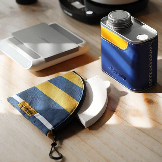 Airtight metal coffee and tea canister with portable filter paper storage, perfect for camping and home use