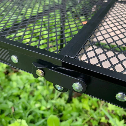 Adjustable portable folding camping table with aluminium frame, black in colour, set up outdoors