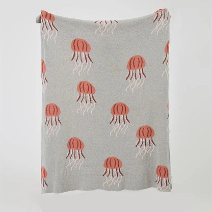 Cosy jellyfish-patterned cotton knit throw blanket in green and grey colours, showcasing its soft, plush texture and unique design.