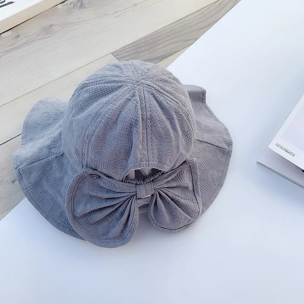 Adorable pink princess baby bucket hat with bow detail for sun protection and fashionable wear