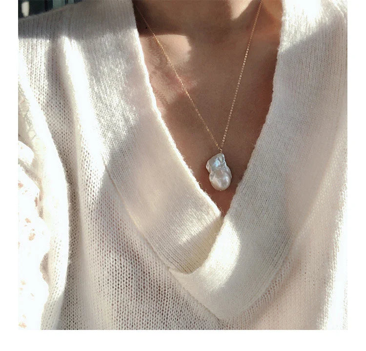 Elegant freshwater pearl necklace with a unique fish tail-shaped pendant and a delicate O-shaped chain