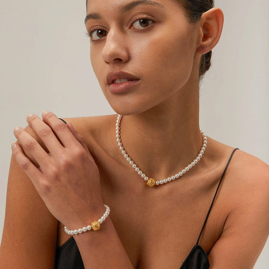 An elegant 18K gold-plated stainless steel bracelet featuring a flower ball design with a lustrous pearl centre