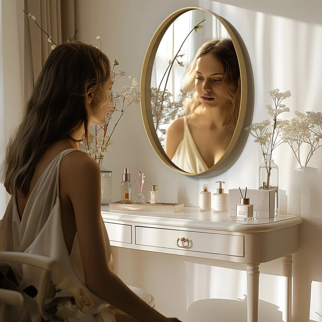 Elegant oval gold wall mirror with a contemporary decorative brushed gold frame