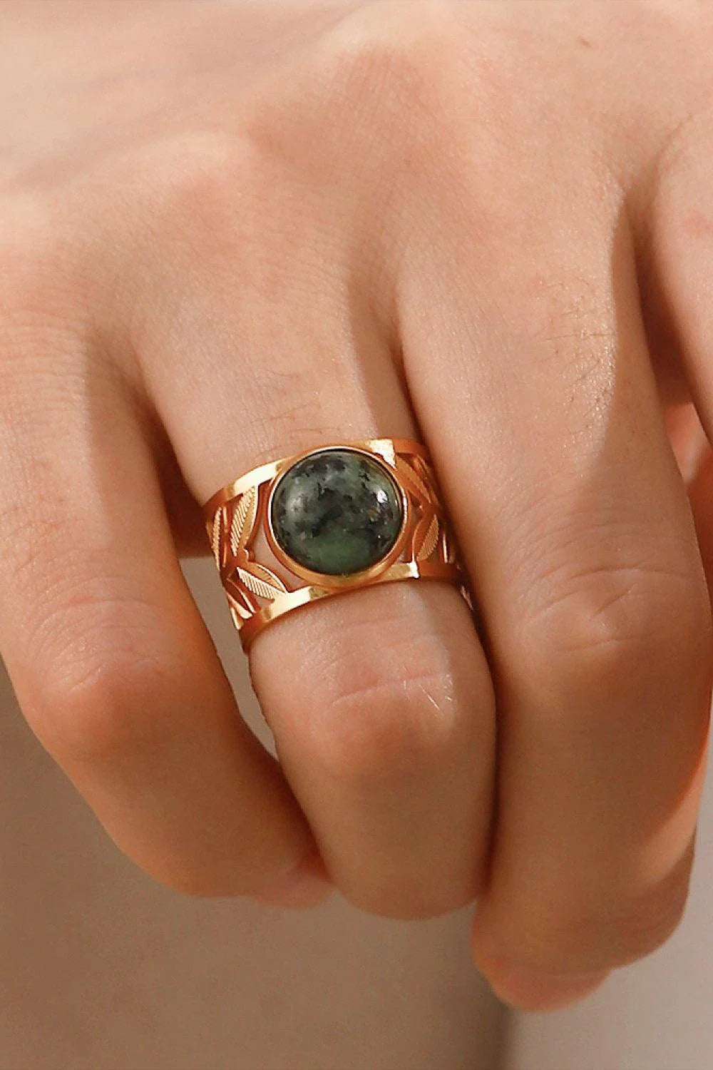 Elegant 18K gold-plated malachite leaf ring in a flat lay, studio style photograph